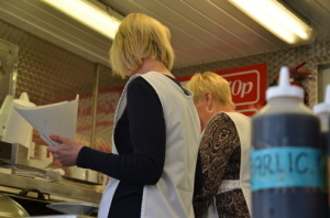 Tracy manning (front) fills a cup with chips at her Chips Stand in Market Square, Great Yarmouth